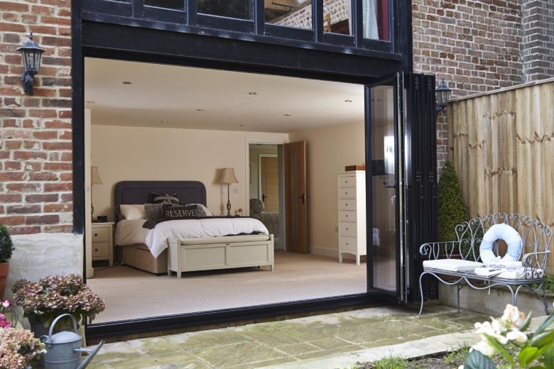 After customer testimonial of open black aluminium bifold doors from Anglian Home Improvements