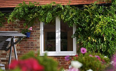 Exterior view of open white uPVC window with triple glazing from Anglian Home Improvements