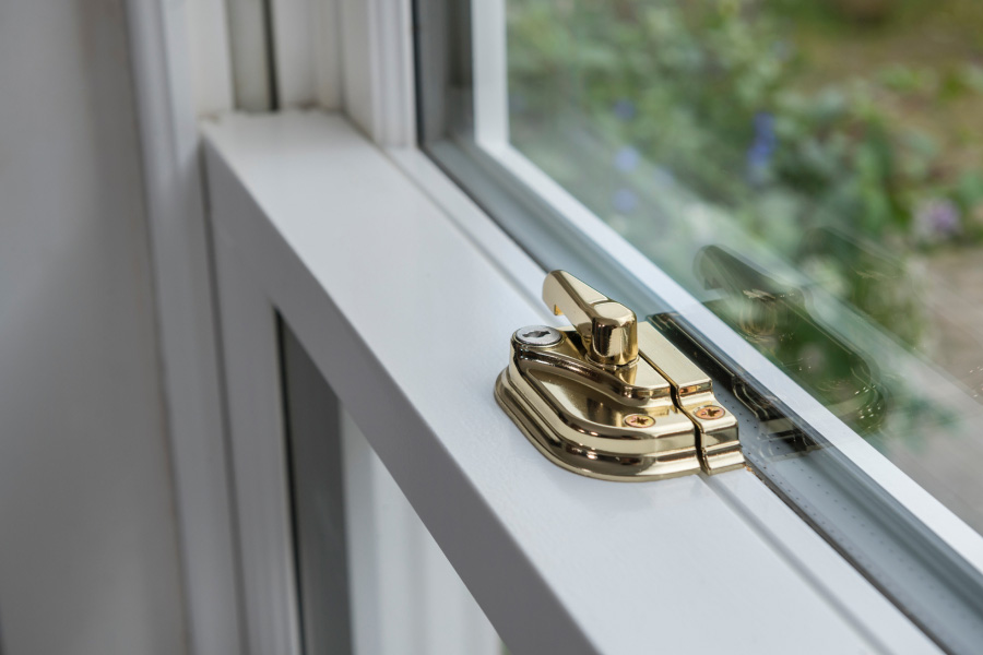 Gold Locking Mechanism on White Wooden Sash Window Close Up