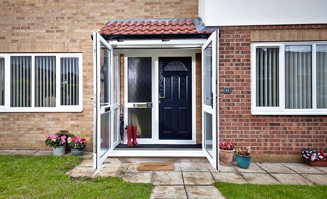 White uPVC porch with open French doors and Steel Blue traditional composite front door inside finished with polished chrome hardware