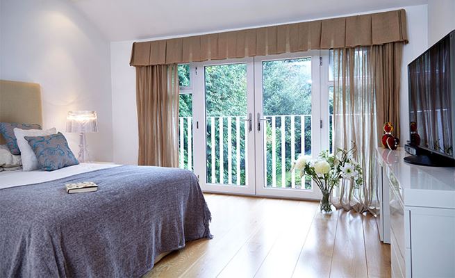 Pair of white uPVC French doors leading to bedroom balcony from the Anglian French doors range