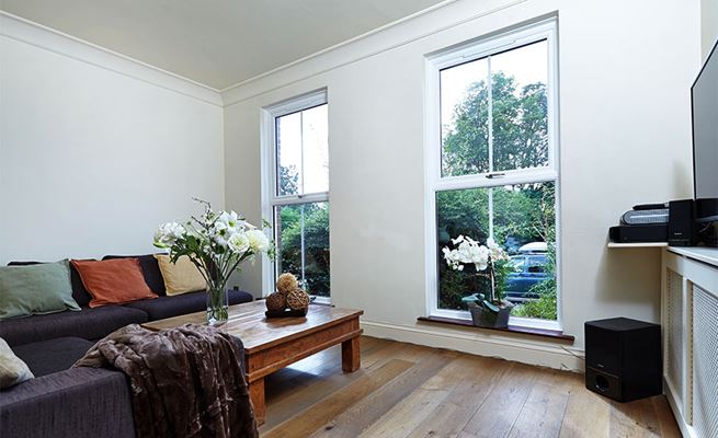 Top-hung lounge UPVC casement windows finished in white with Georgian bars and chrome handles