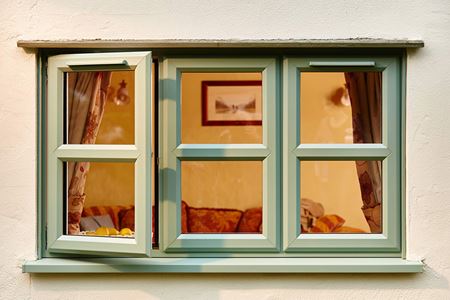 Double glazed UPVC casement windows finished in dual Sage Green and White with cottage bars from Anglian Home Improvements