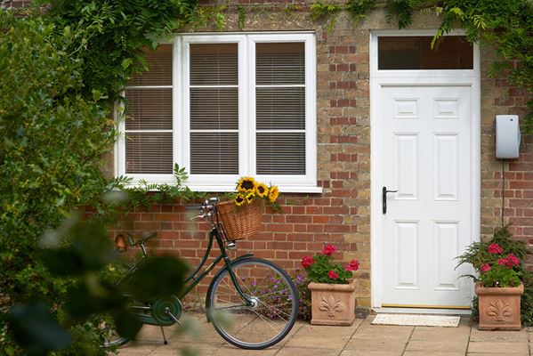 White UPVC external door with transom and matching triple glazed windows from Anglian Home Improvements