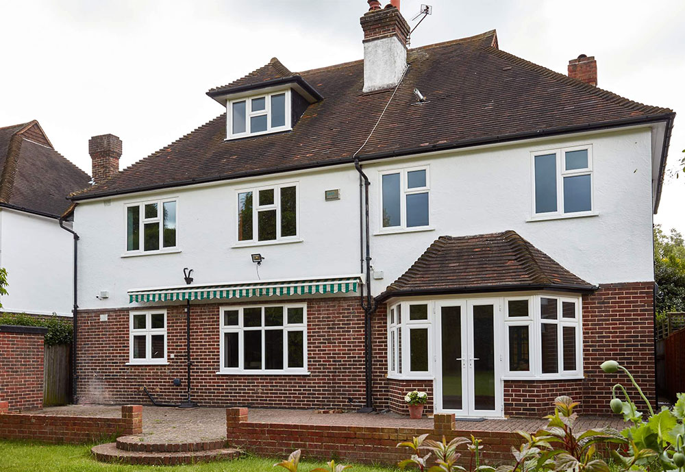 Triple glazed UPVC windows and French doors finished in white on large family home from the Anglian windows and doors range