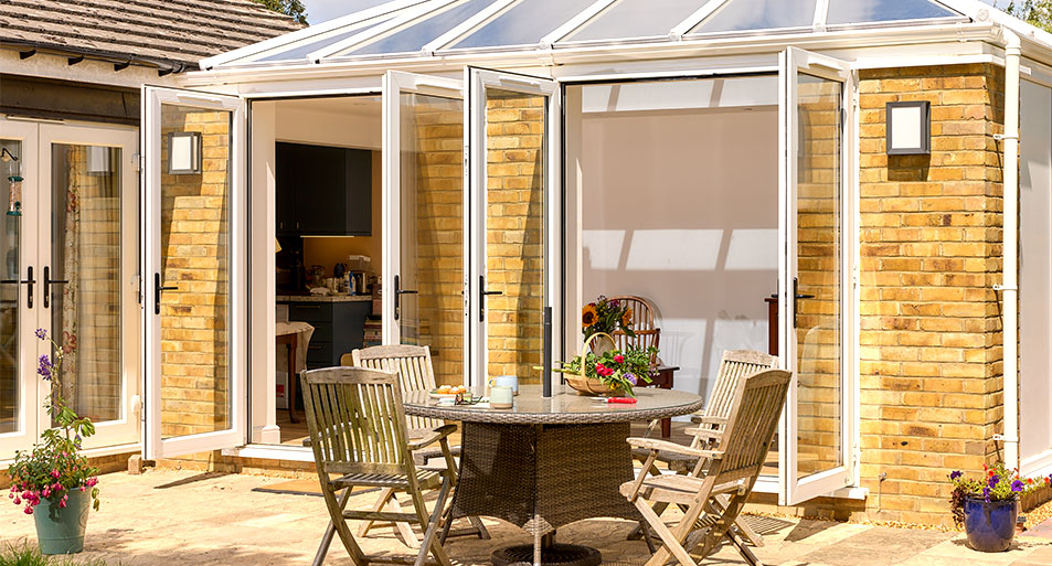 Two Open White uPVC French Doors with Black Handles on a Brick Pillar Orangery