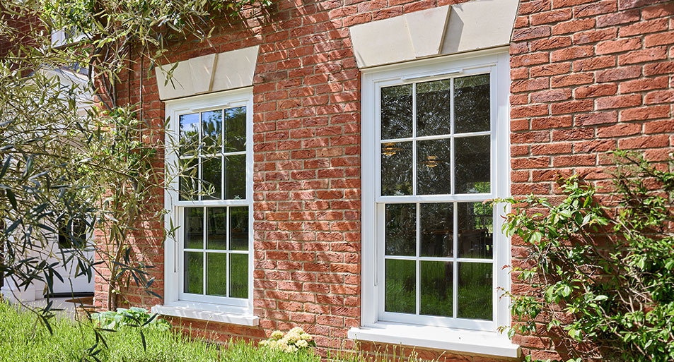 White uPVC Sliding Sash Windows in a Georgian Chequerboard Design on a Red Brick House