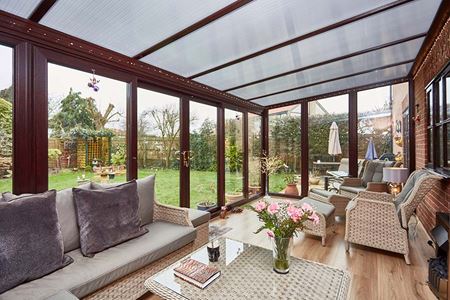 Dark woodgrain uPVC lean to conservatory with polycarbonate roof