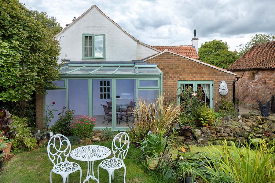 Dual Sage green uPVC lean to with French doors and casement windows