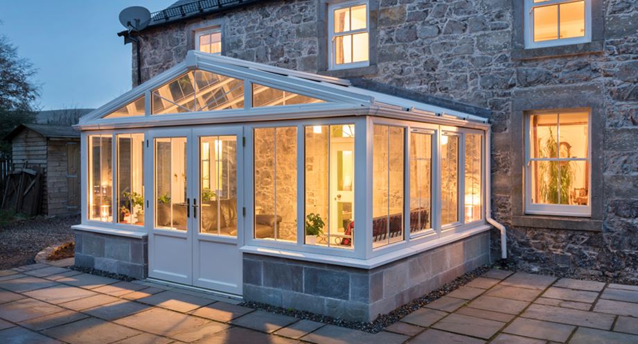 White uPVC Regency conservatory showing triangle windows in evening
