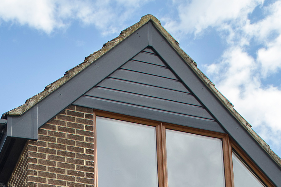 Black uPVC bargeboard with golden oak windows