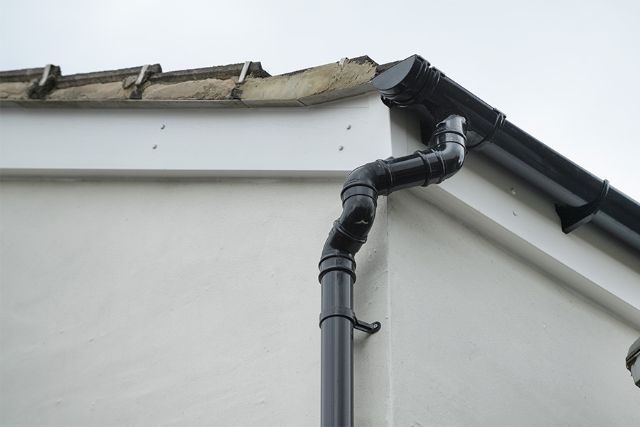 White uPVC bargeboard with black guttering close up