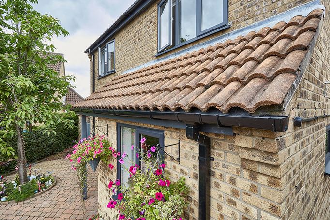 Black uPVC guttering and anthracite grey windows front of house