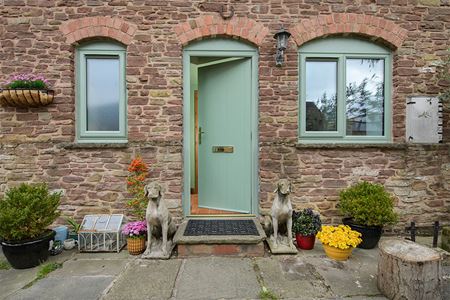 Dual sage green uPVC shaped casement windows and matching front door