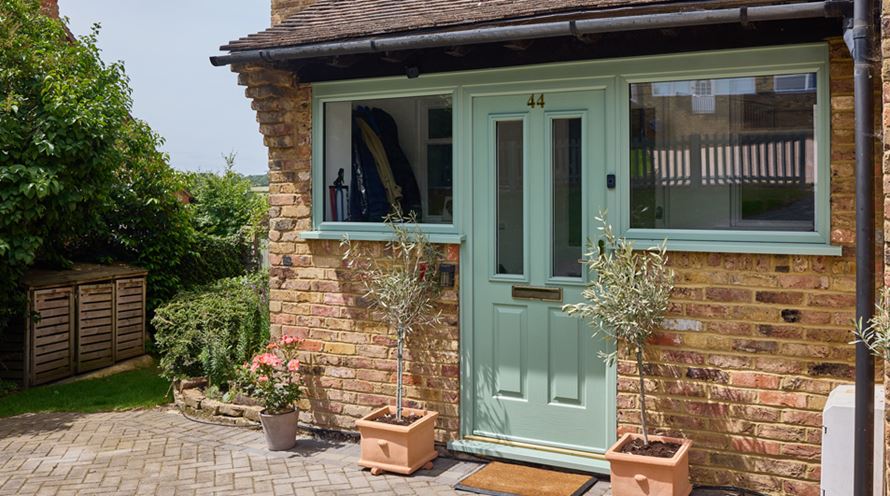 Sage green uPVC casement windows and matching front door banner
