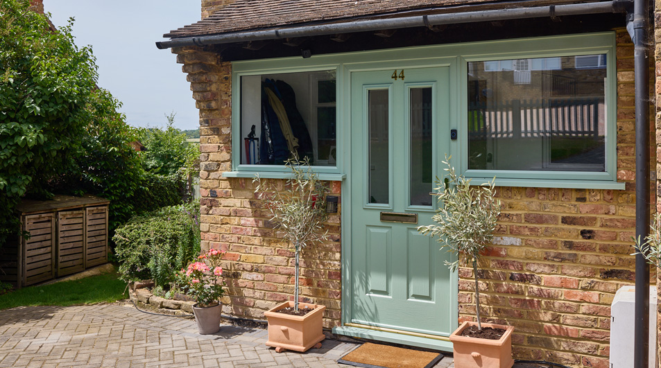 Sage green uPVC casement windows and matching front door banner