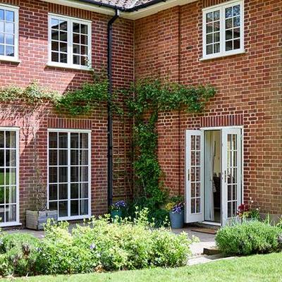 Cream timber casement windows with Georgian insert bars and French doors