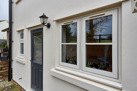 Cream uPVC flush casement windows with anthracite grey composite doors