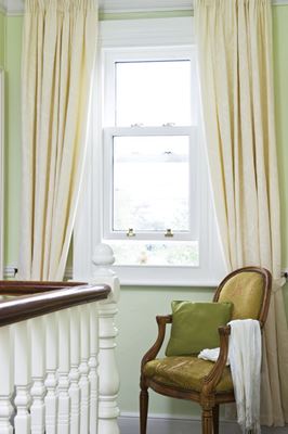 White wooden sash window with gold sash pull handles on landing hallway from Anglian Home Improvements